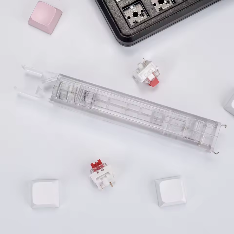 Clear Lift transparent two-ended removal tool beside a keyboard, loose keycaps and switches. One tool is included; other items are props. Supplier photo.