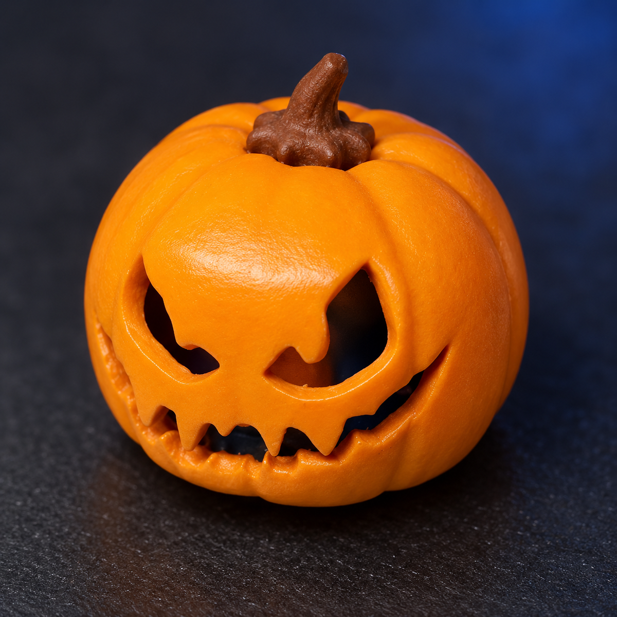 Pumpkin Glow keycap: close-up of the sculpted orange face and brown stem.