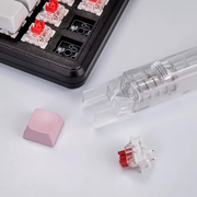 Close-up of the plastic removal end of Clear Lift beside keyboard switches and keycaps, which are not included. Supplier photo.
